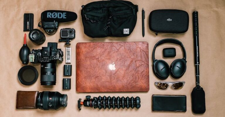 Digital Media Tools - Overhead view of laptop and photo camera composed with headphones and other gadgets of professional photographer