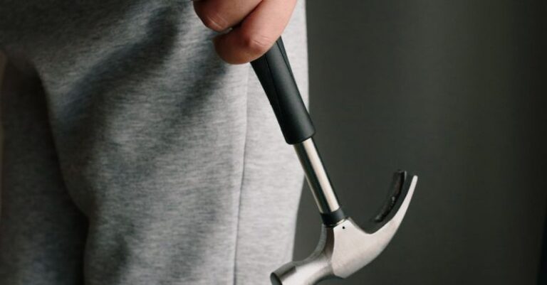 Design Tools - Crop unrecognizable male in casual clothes holding metal hammer with rubber handle in room