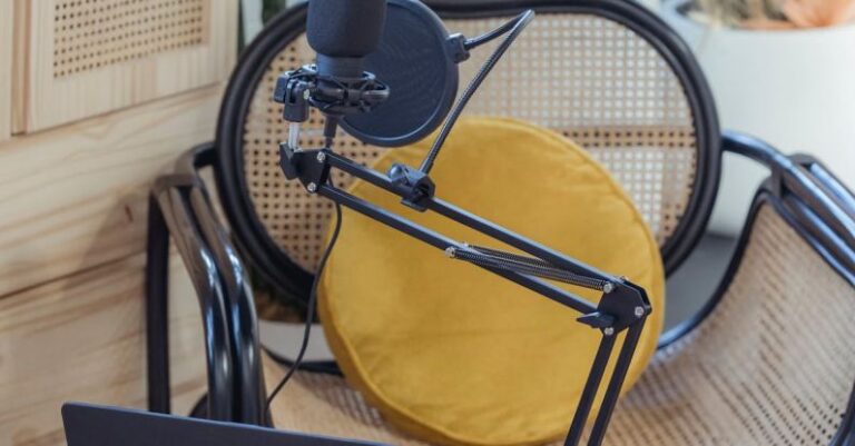 Video Shoots - Modern laptop and microphone on tripod placed near wicker chair in modern studio before recording podcast